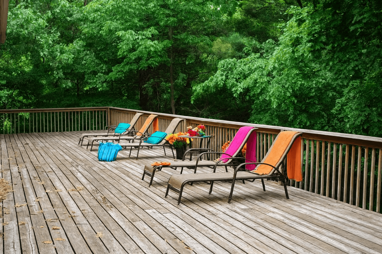 A wooden deck with chairs and a table.